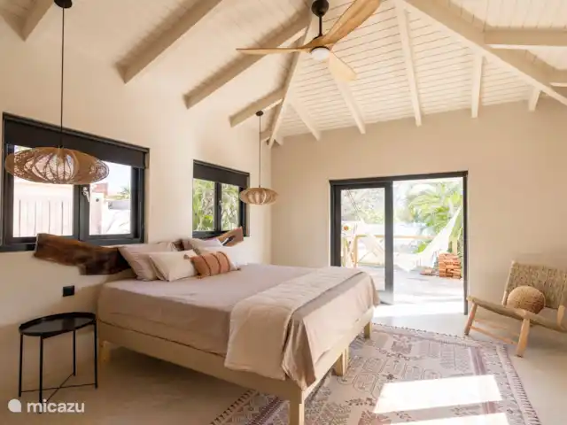 Location de Vacances Curaçao, Banda Ariba (est), Jan Thiel, maison de vacances - Casa Cosi Curaçao - Plage Jan Thiel Chambre principale numéro 1, avec salle de bain privée et portes patio donnant sur la terrasse de la piscine.