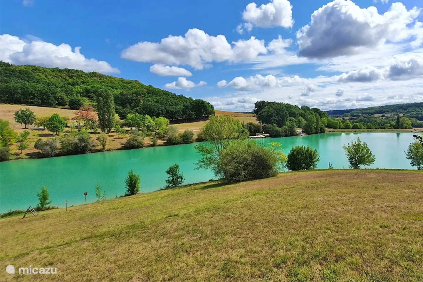 In der Nähe befindet sich ein türkisfarbener See mit Strand