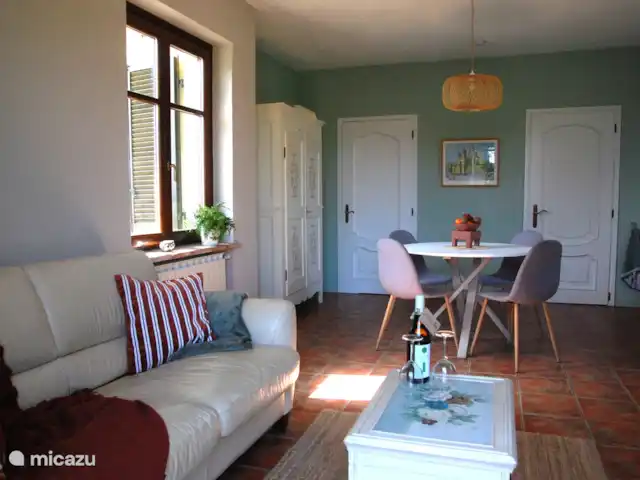 Casavabene Appartement Cinghiale huren in Italië, Piëmont, Murazzano - appartement De gezellige woonkamer heeft een zitje bestaande uit een bank en fauteuil, een eethoek en een keuken.