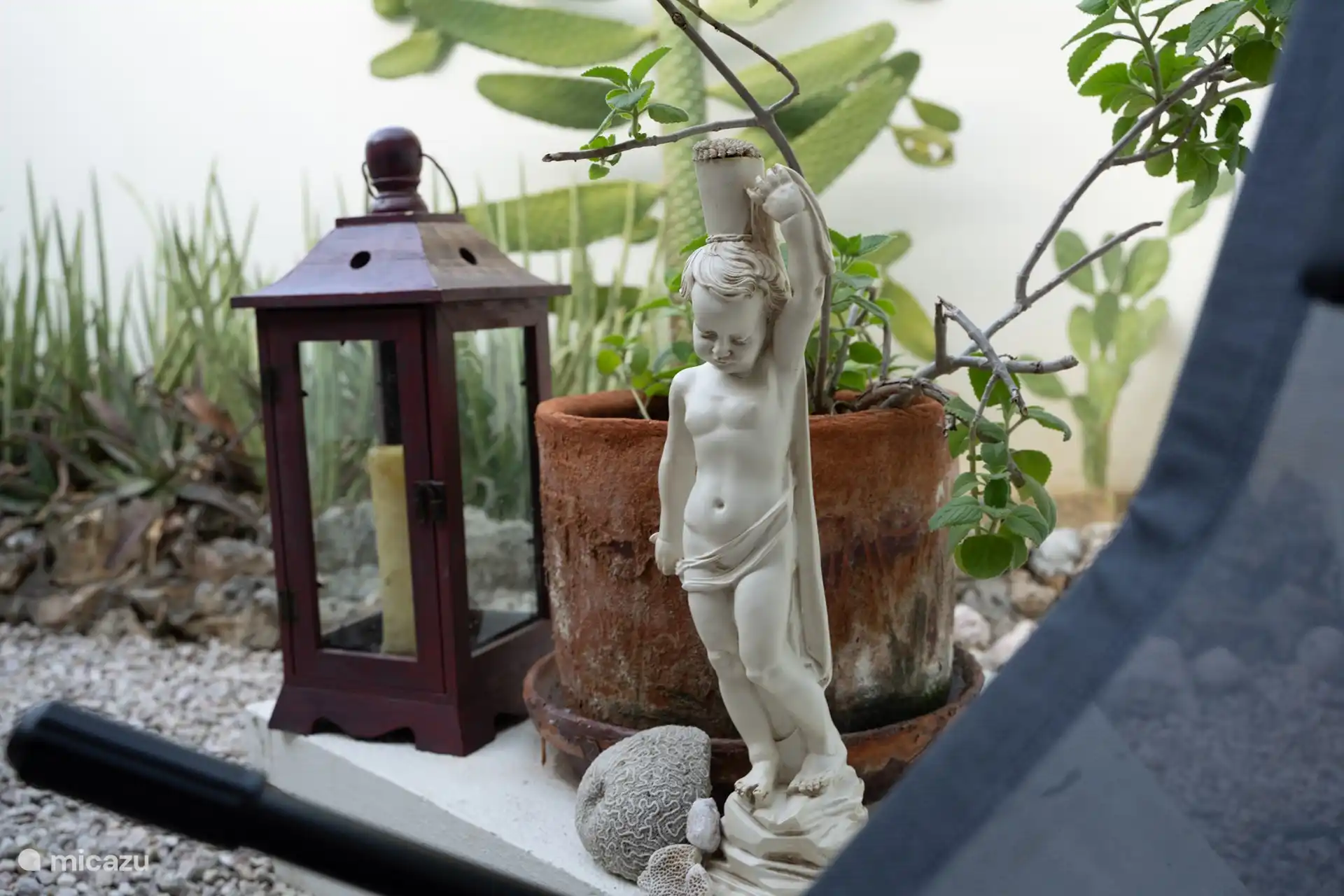 Beautiful garden with careful details, including decorative figurines and green accents, creating a serene and inviting atmosphere.