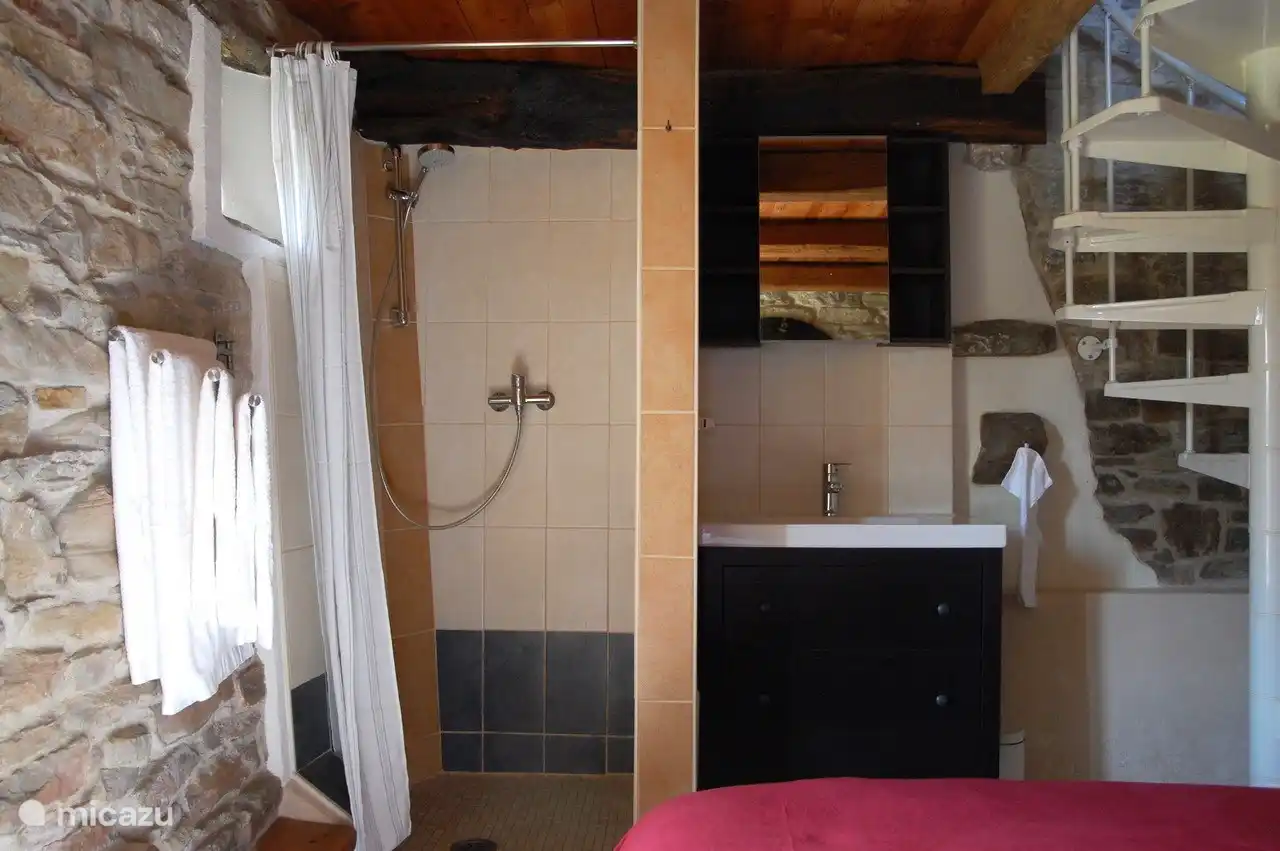 Das Schlafzimmer im Erdgeschoss verfügt über ein offenes Badezimmer. Es gibt eine separate Toilette.