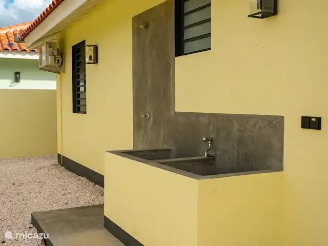 Location de Vacances Bonaire, Bonaire, Kralendijk, villa - Villa 5 Geel Courtyard Village Les moulinets de snorkeling et de plongée peuvent être rincés derrière la maison. Il y a aussi une douche extérieure ici