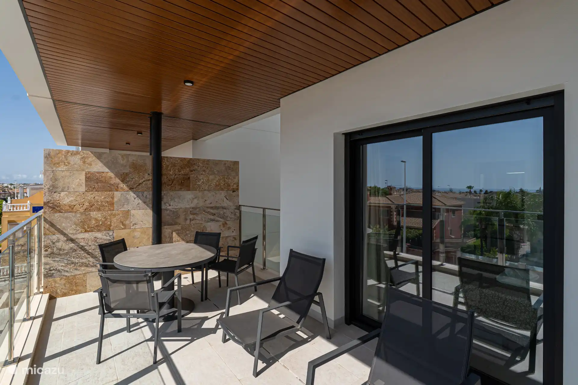 Terrasse avec coin repas et chaises longues paresseuses. 