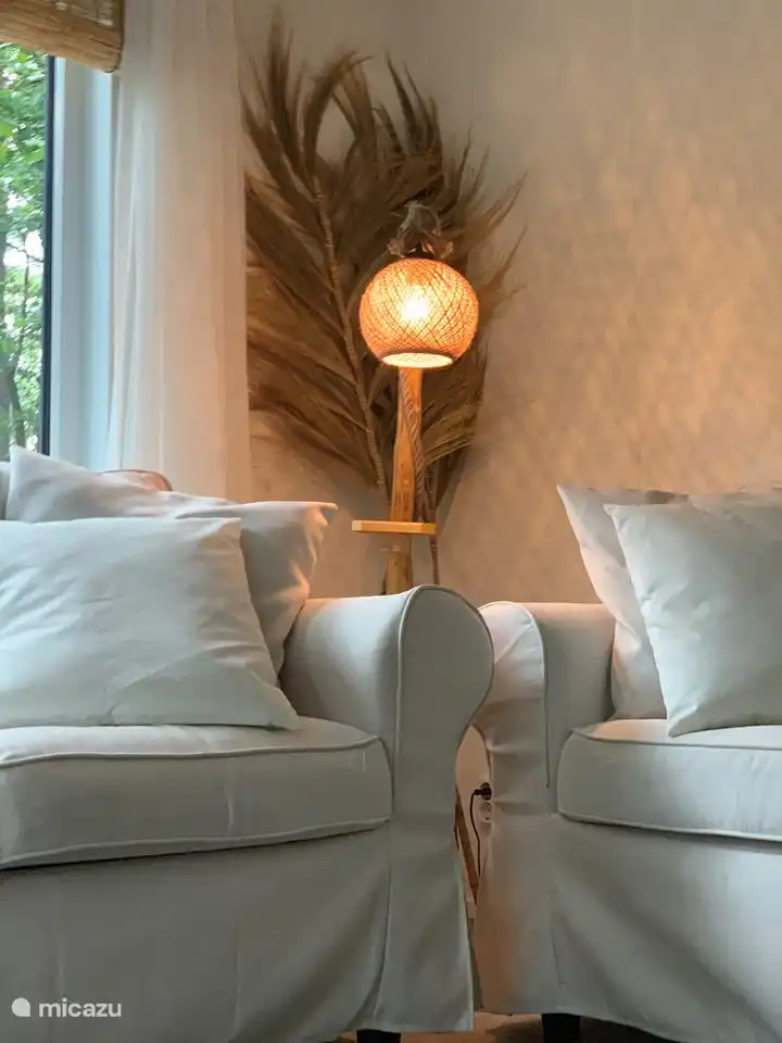 Das Wohnzimmer hat viel Licht durch die großen Fenster und Schiebetüren zur Terrasse