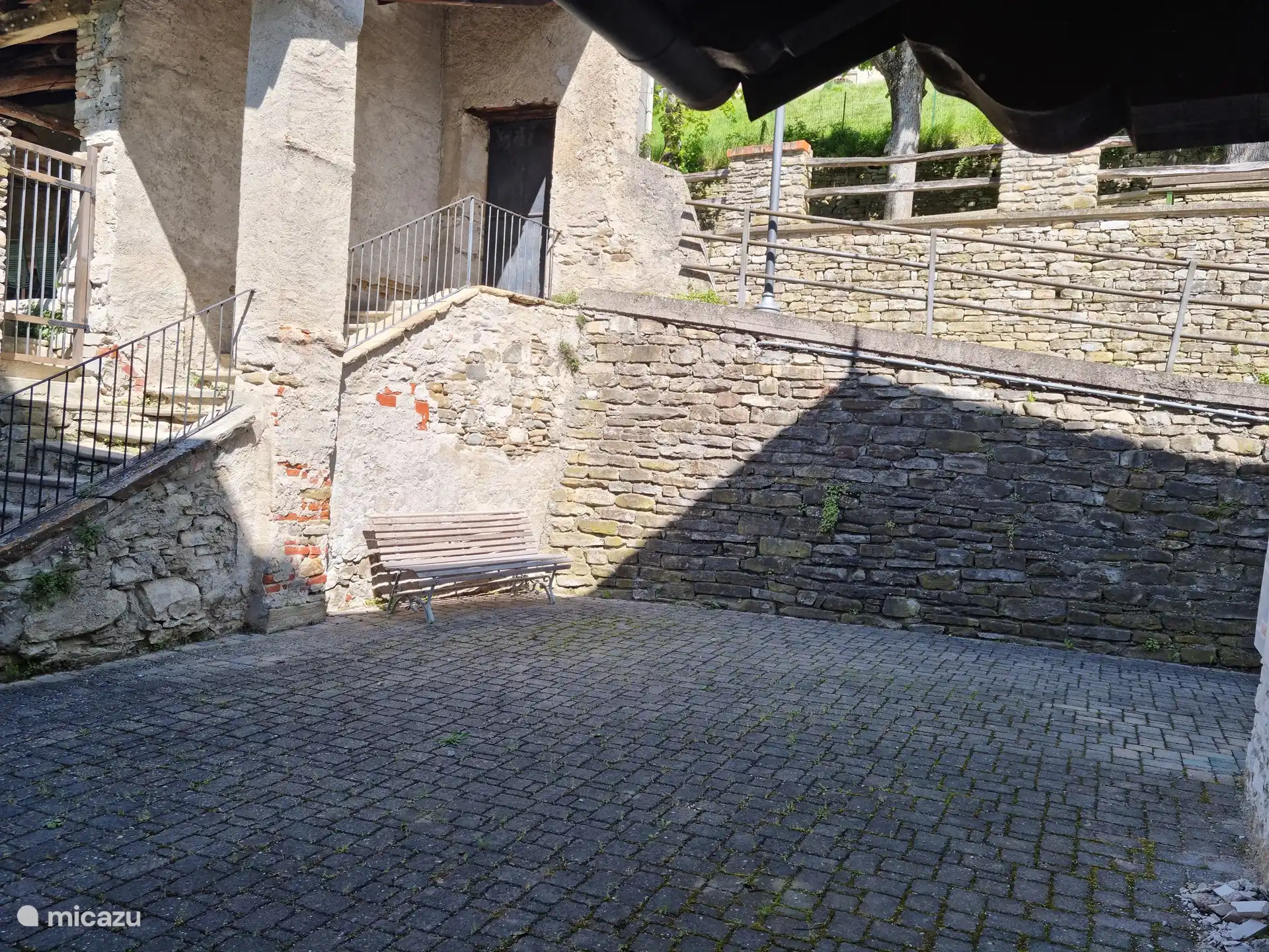 Einer der Sitzbereiche, um die Morgensonne zu genießen. In den Sommermonaten ist dieser Standort aufgrund der langanhaltenden Beschattung etwas kühler. Hier gibt es auch genügend Platz, um ein Auto zu parken.