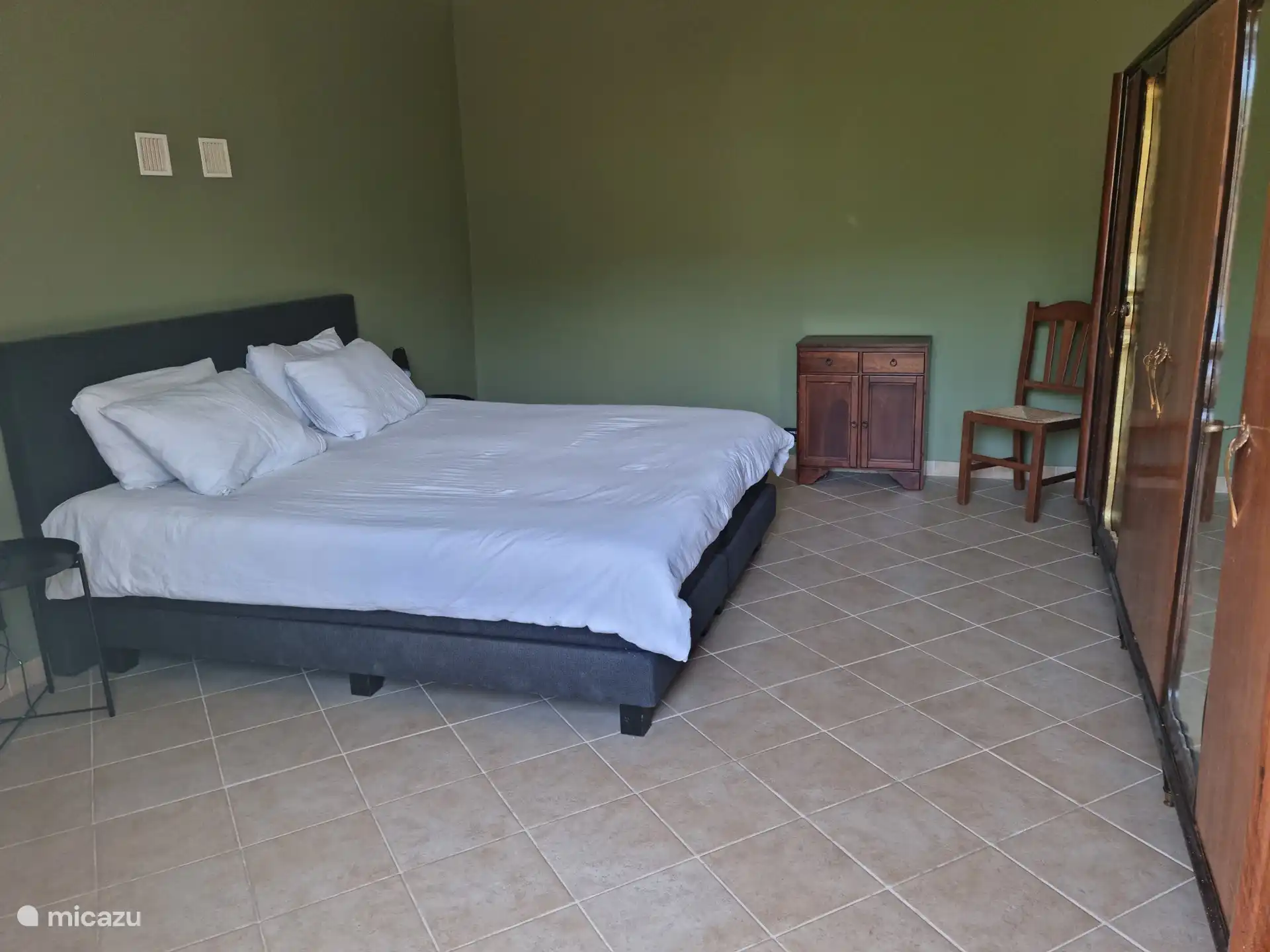 Schlafzimmer mit geräumigem Doppelbett und Blick auf den Garten.