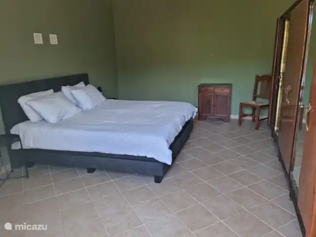 canónica en Italia, Piamonte, Monesiglio - apartamento Dormitorio con amplia cama de matrimonio con vistas al jardín.
