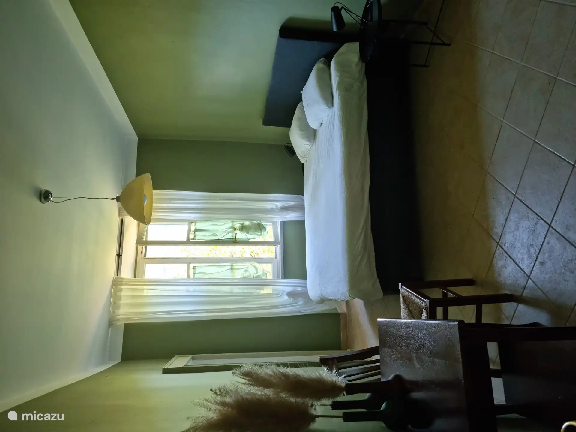 Schlafzimmer mit großzügigem Doppelbett, diversen (Einbau-)Schränken und Blick in den Garten. Natürlich mit Rollläden.