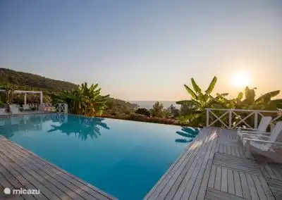 zonsondergang aan het prachtige overloop zwembad