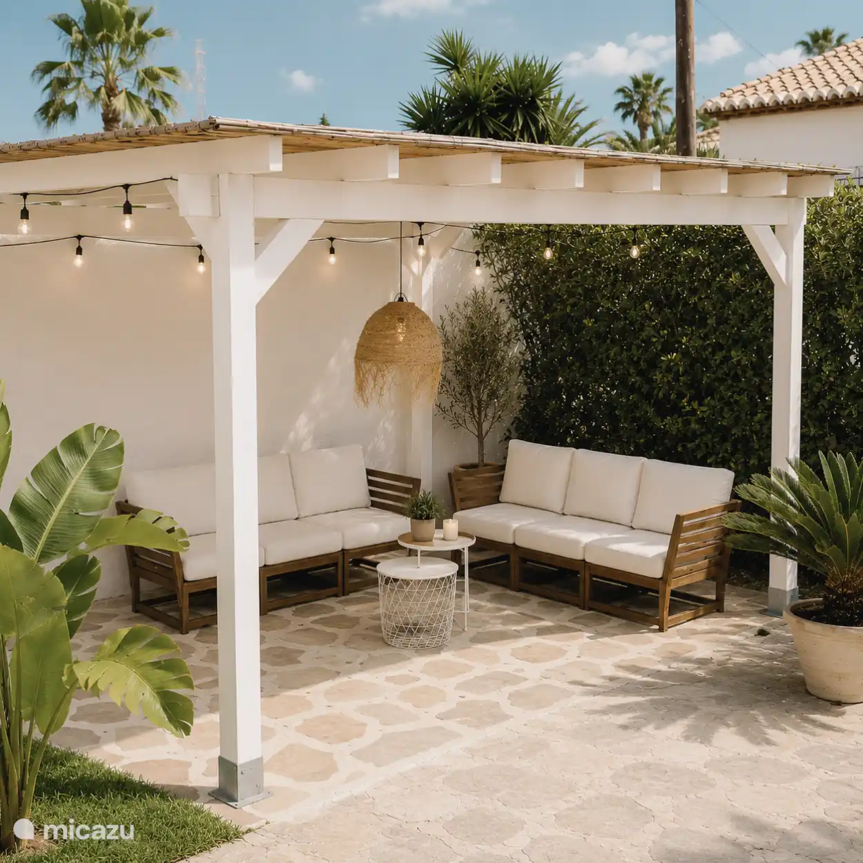 Toldo con zona de descanso en la parte trasera de la casa.