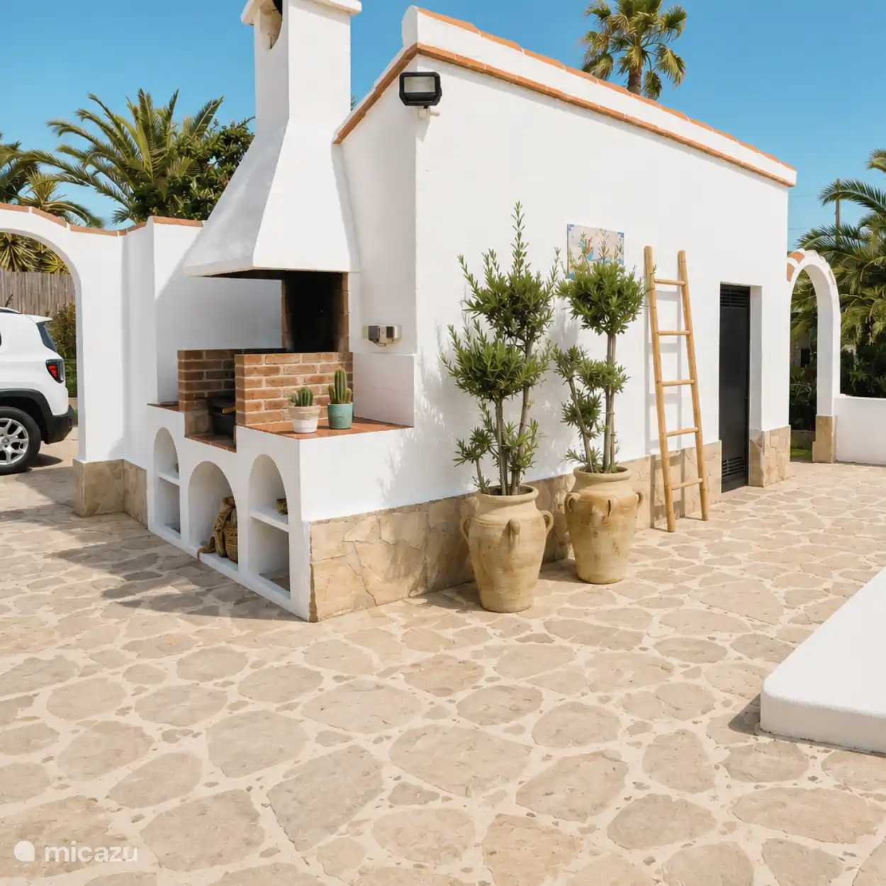 La pequeña cocina exterior con zona de barbacoa.