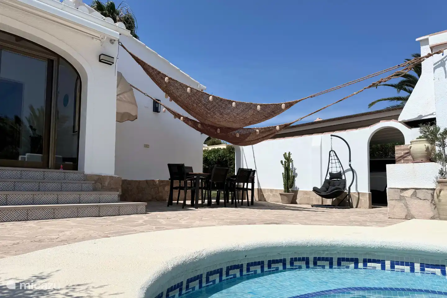 Außenterrasse mit Kokosnuss-Schattentüchern.