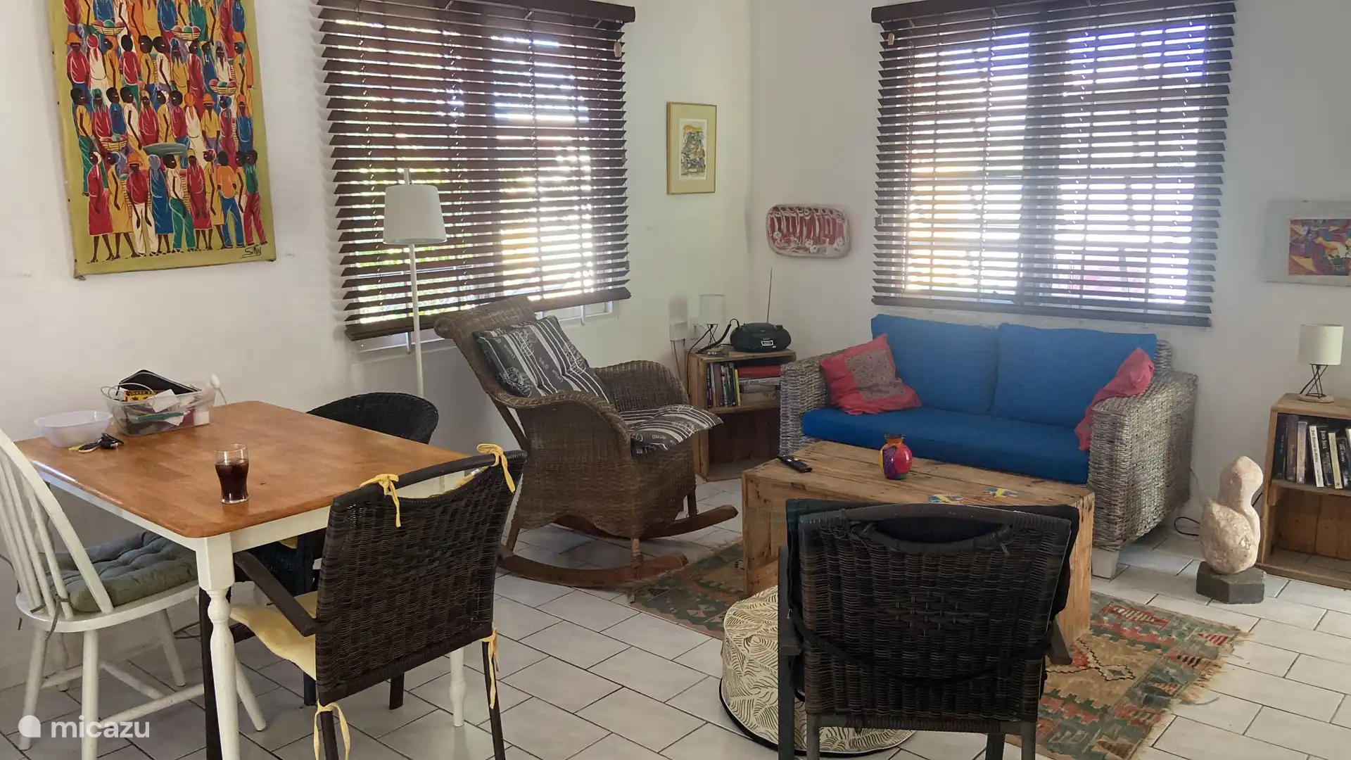 La acogedora sala de estar con sofá de dos plazas, silla y mecedora.