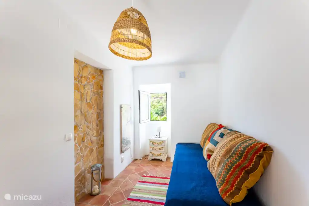 2e slaapkamer met tweepersoons slaapbank. Openslaande deuren naar de patio.