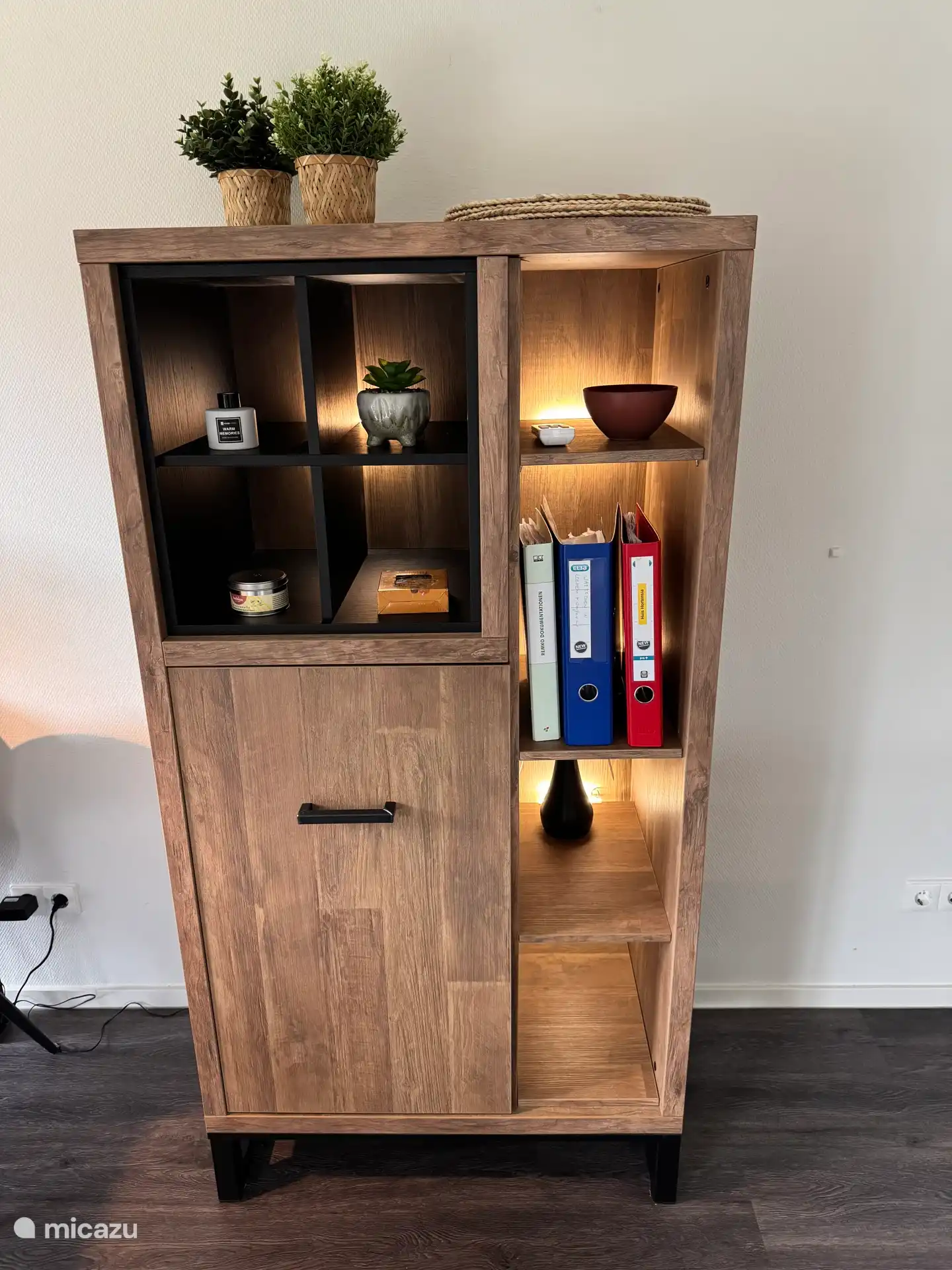 kast met informatiemappen, schaal met pasjes met daarboven n de airco