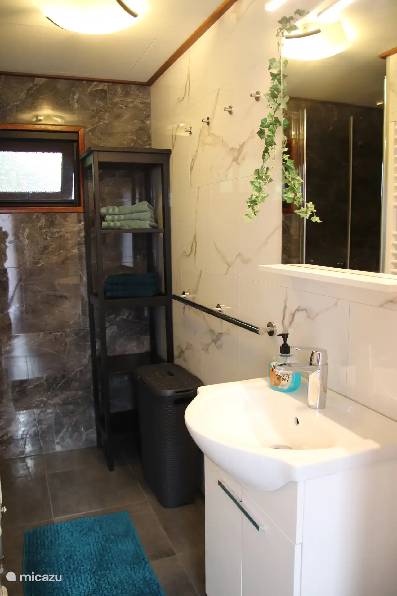 Badezimmer mit Duschbereich und Waschbecken