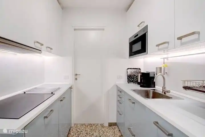 Die neue voll ausgestattete Küche verfügt über ein Induktionskochfeld, einen Geschirrspüler, einen Kühlschrank, eine Mikrowelle und eine Kaffeemaschine.