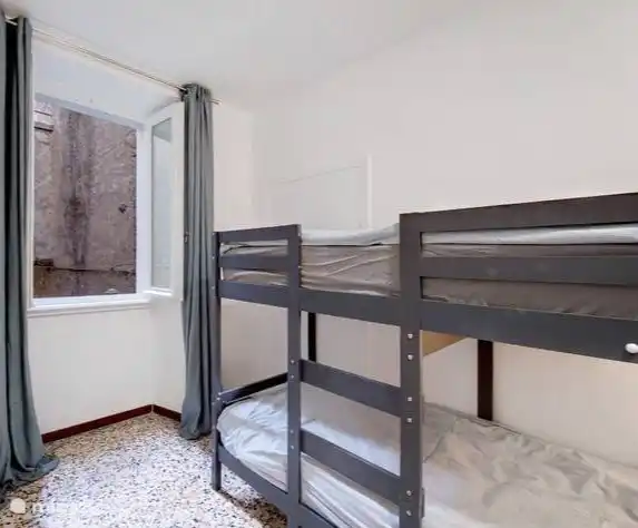 Schlafzimmer mit Etagenbett (80x200cm) und geräumigem Wandschrank.