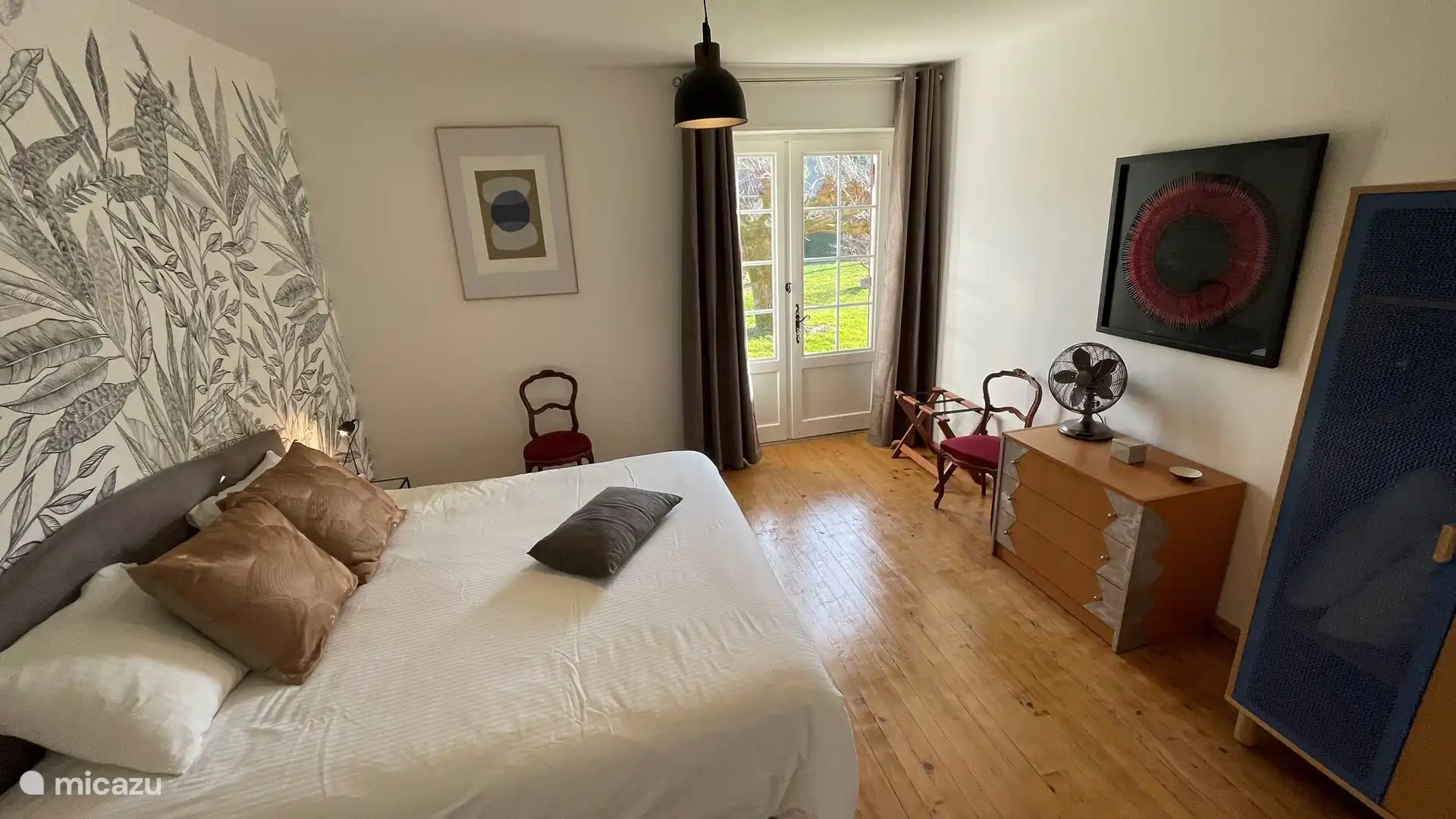 Slaapkamer met openslaande deuren naar de tuin. Kingsize bed.