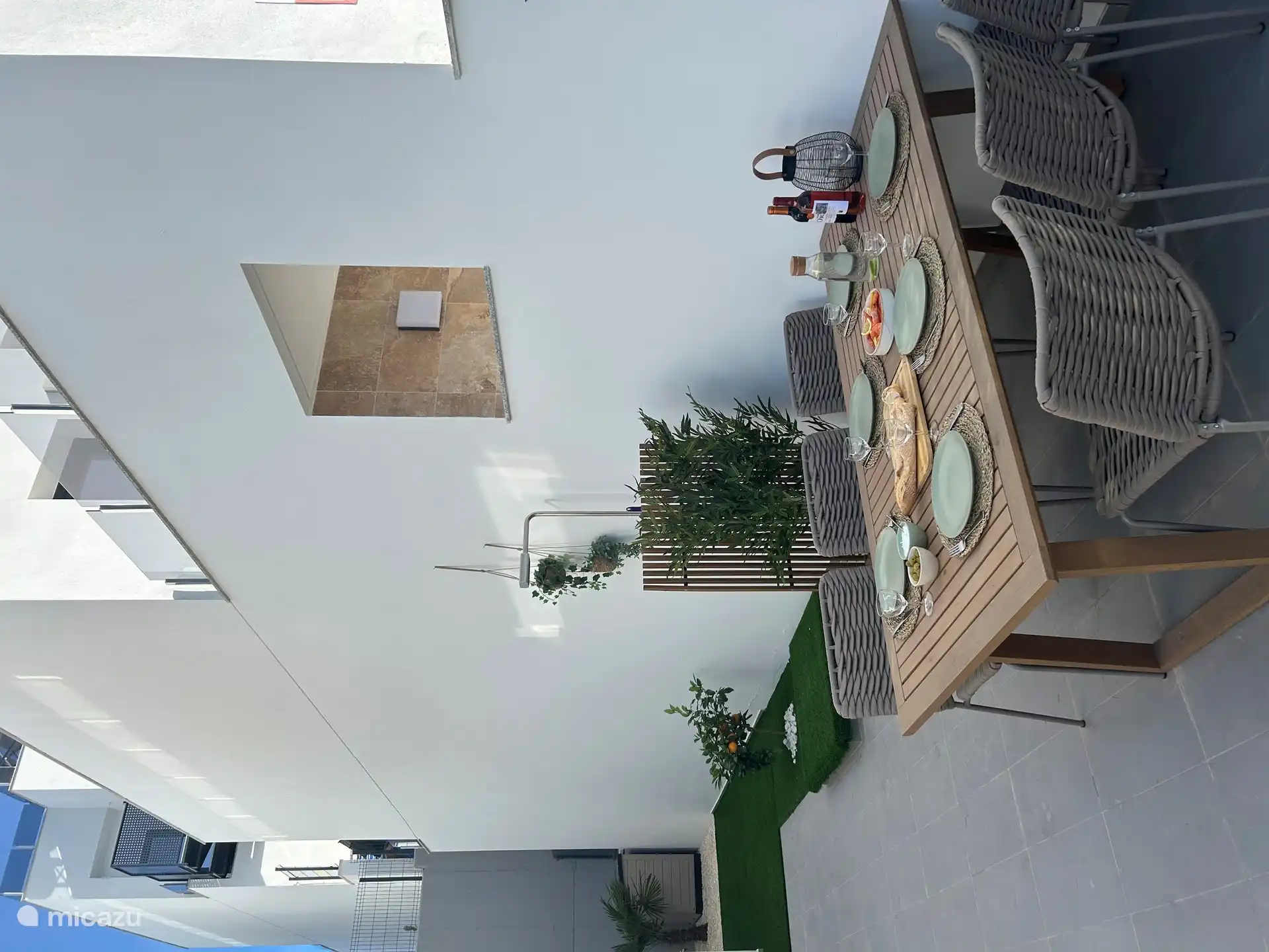 Geräumige Terrasse mit Esstisch, Außendusche und Sonnenliegen.