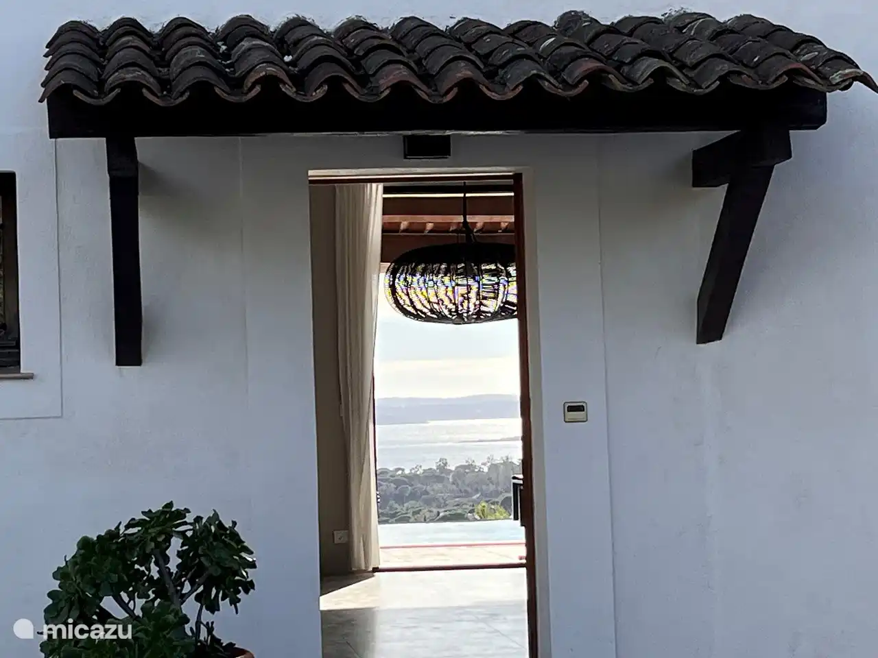 Blick durch die Eingangstür durch die Villa und über den Infinity-Pool auf das Meer