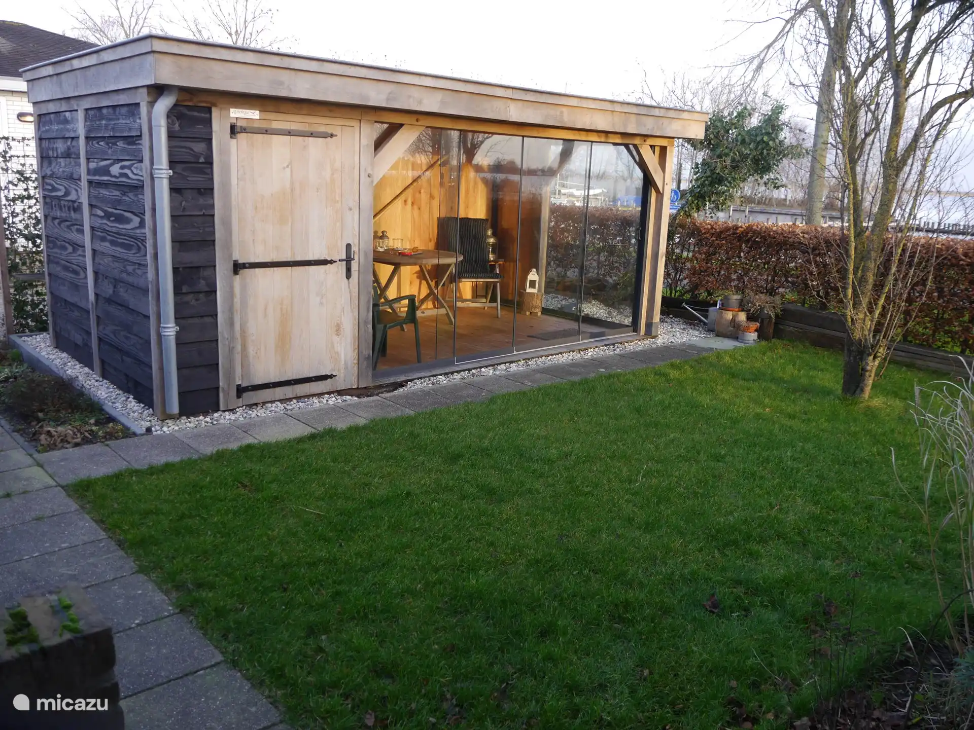 Das Gartenhaus mit Glasschiebetüren und Blick auf den See
