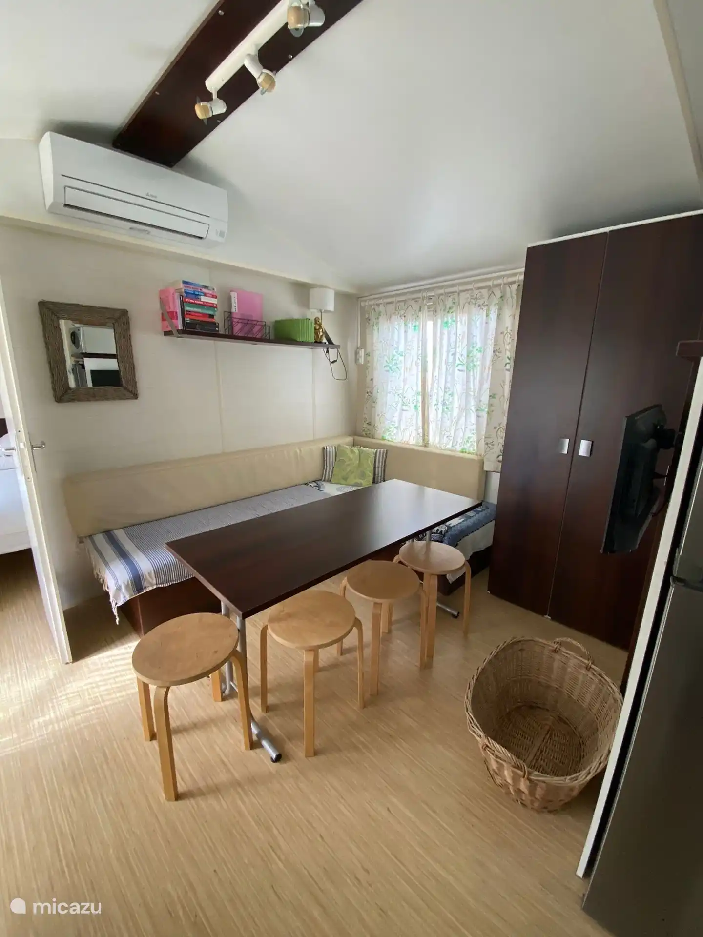 Sala de estar/sala de estar interior con sofá, mesa, sillas y televisión.