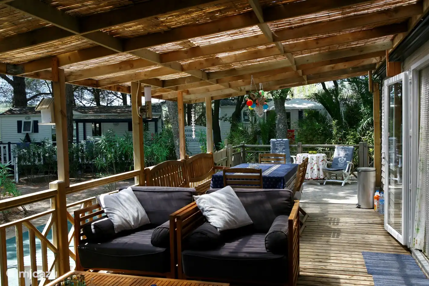 La espaciosa terraza de nuestra casa móvil ofrece espacio para cenar y descansar bajo techo y continúa a la vuelta de la esquina hasta la zona para tomar el sol.