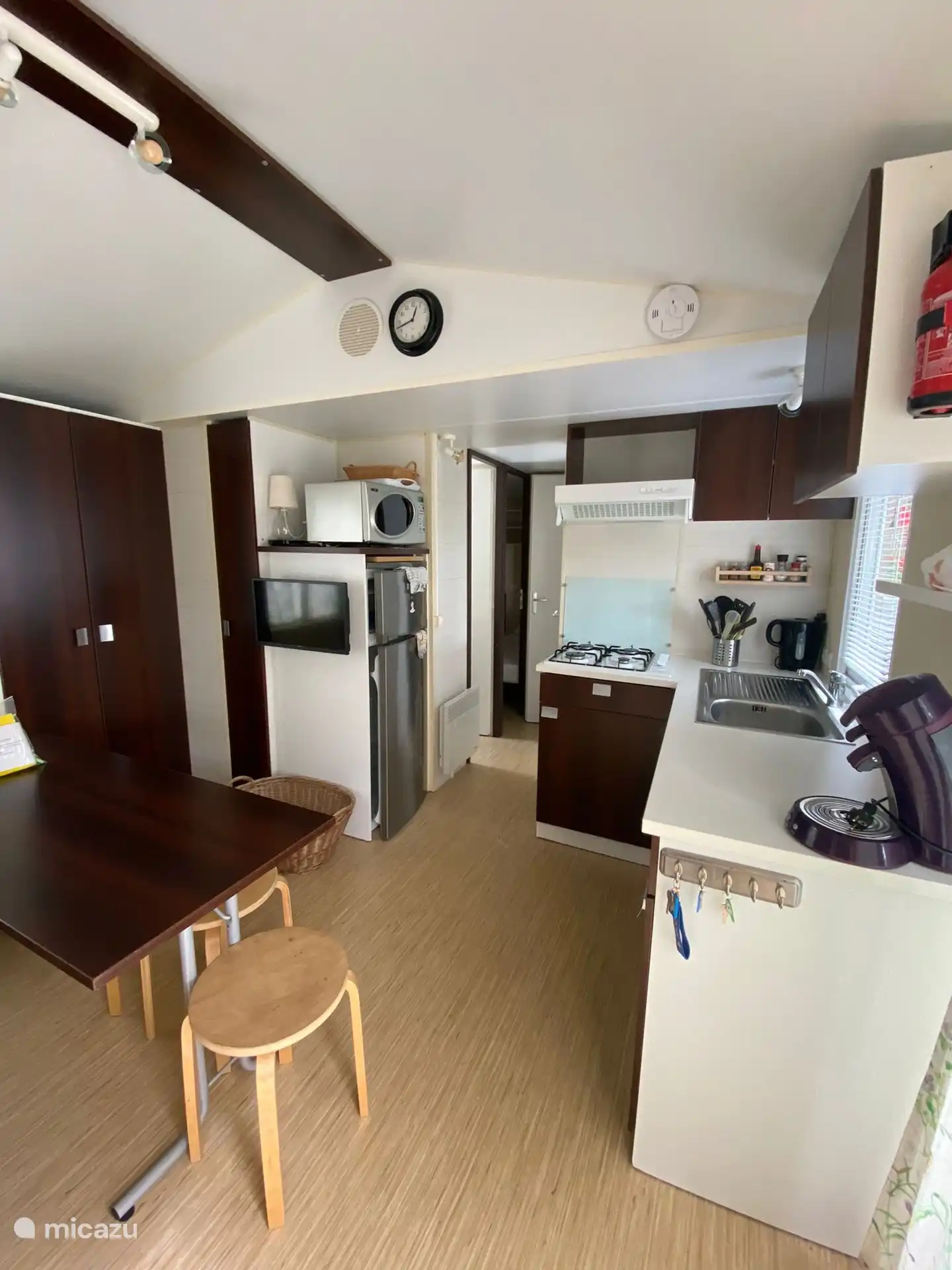 Sala de estar/sala de estar interior con sofá, mesa, sillas y televisión.