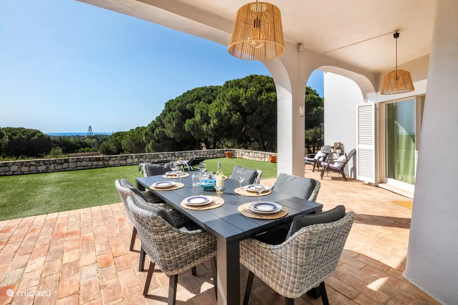 Mesa de comedor exterior en la terraza frente al salón y la cocina.