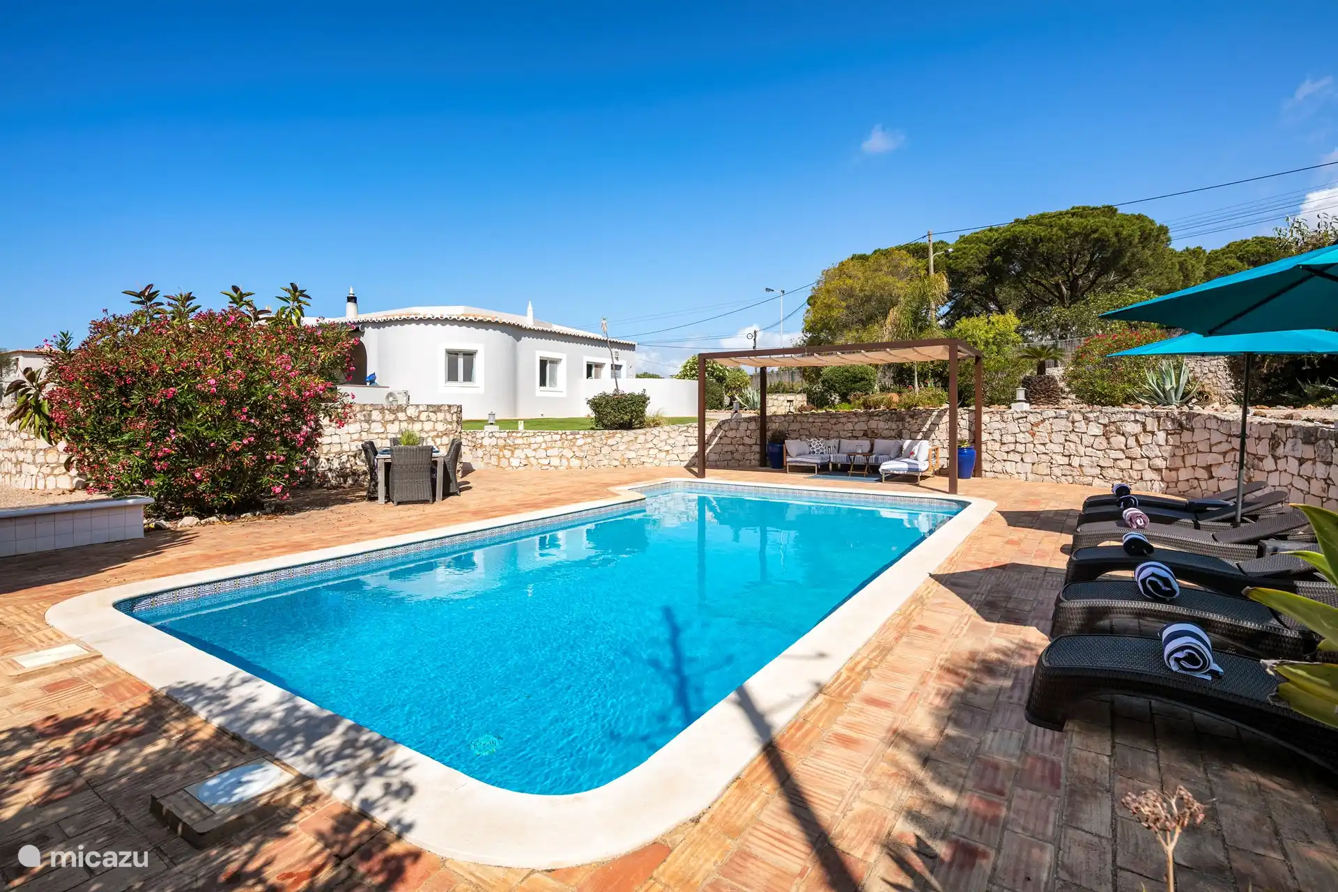 Gran piscina con sala de estar y tumbonas.