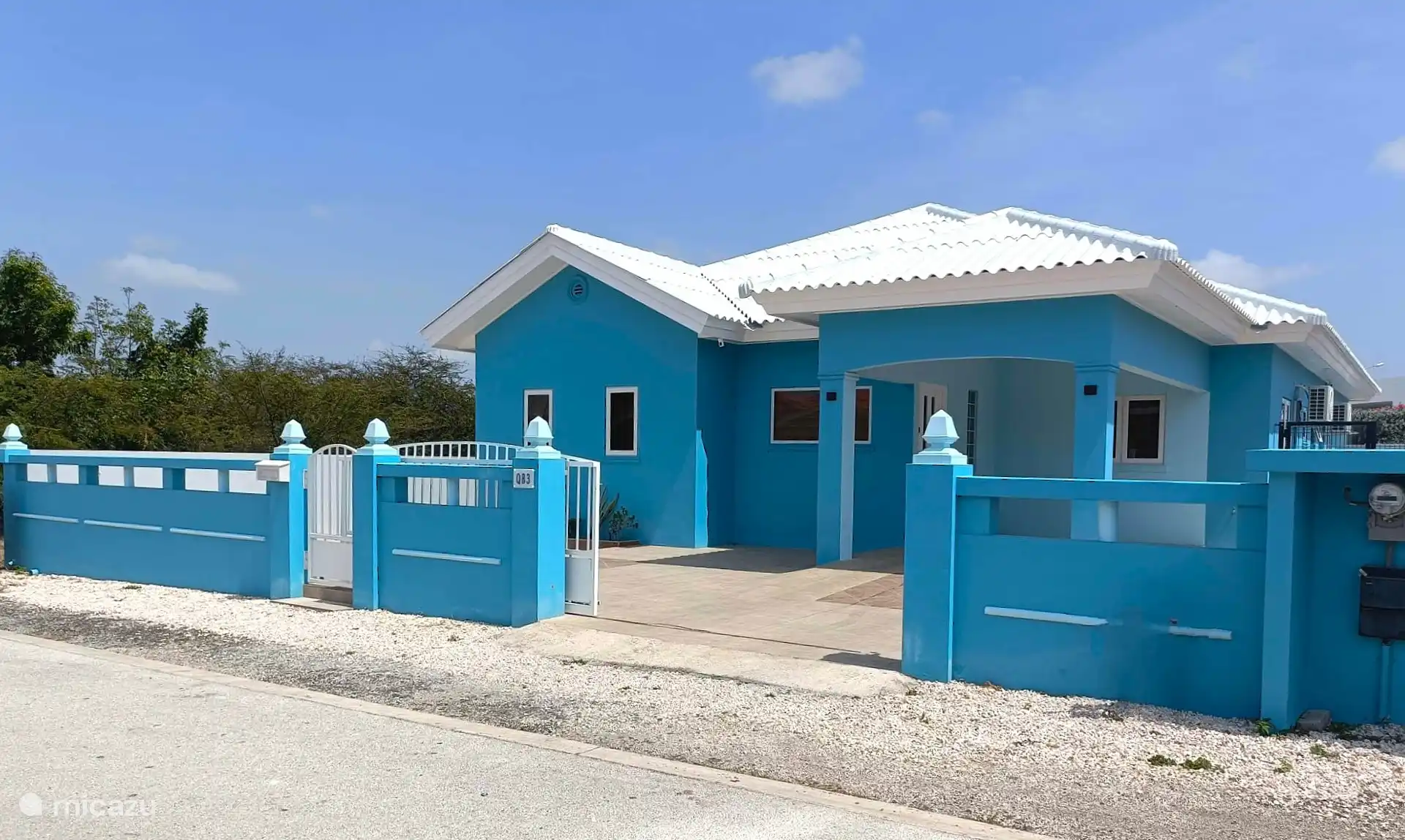 Front of the house with its own driveway and entrance gate.
