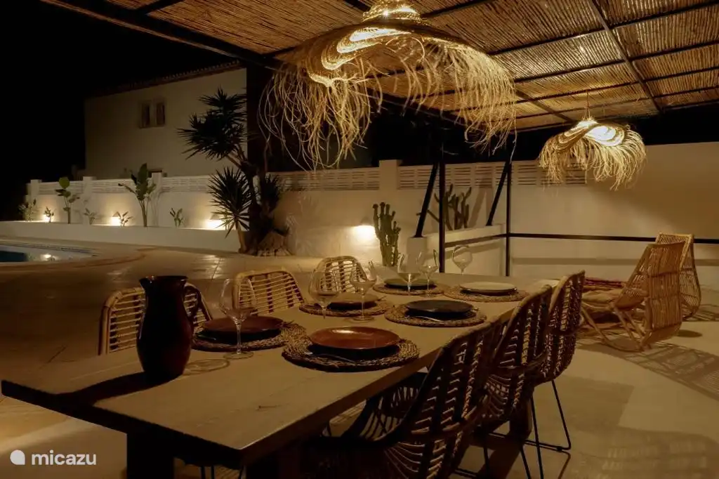 Pergola with dining table and relaxing chairs.