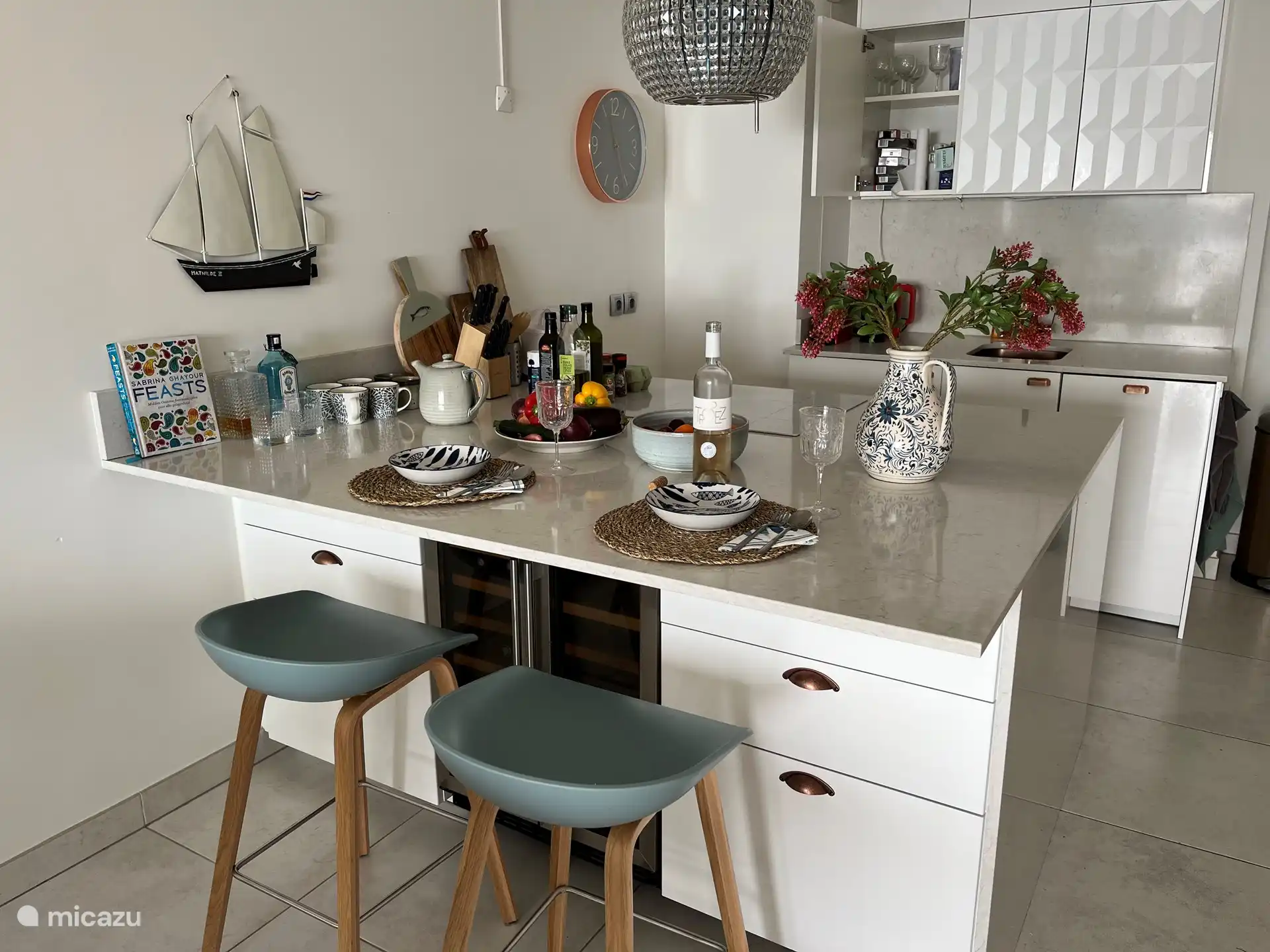 an der Bar sitzen, während andere kochen