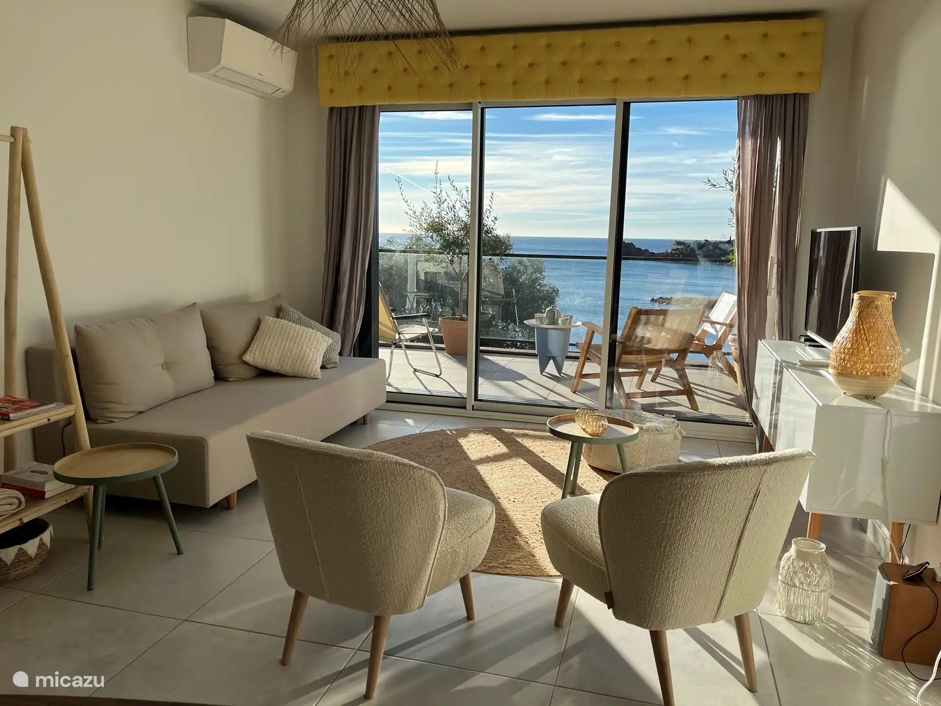 Wohnzimmer mit Schlafsofa und direktem Blick auf das Meer