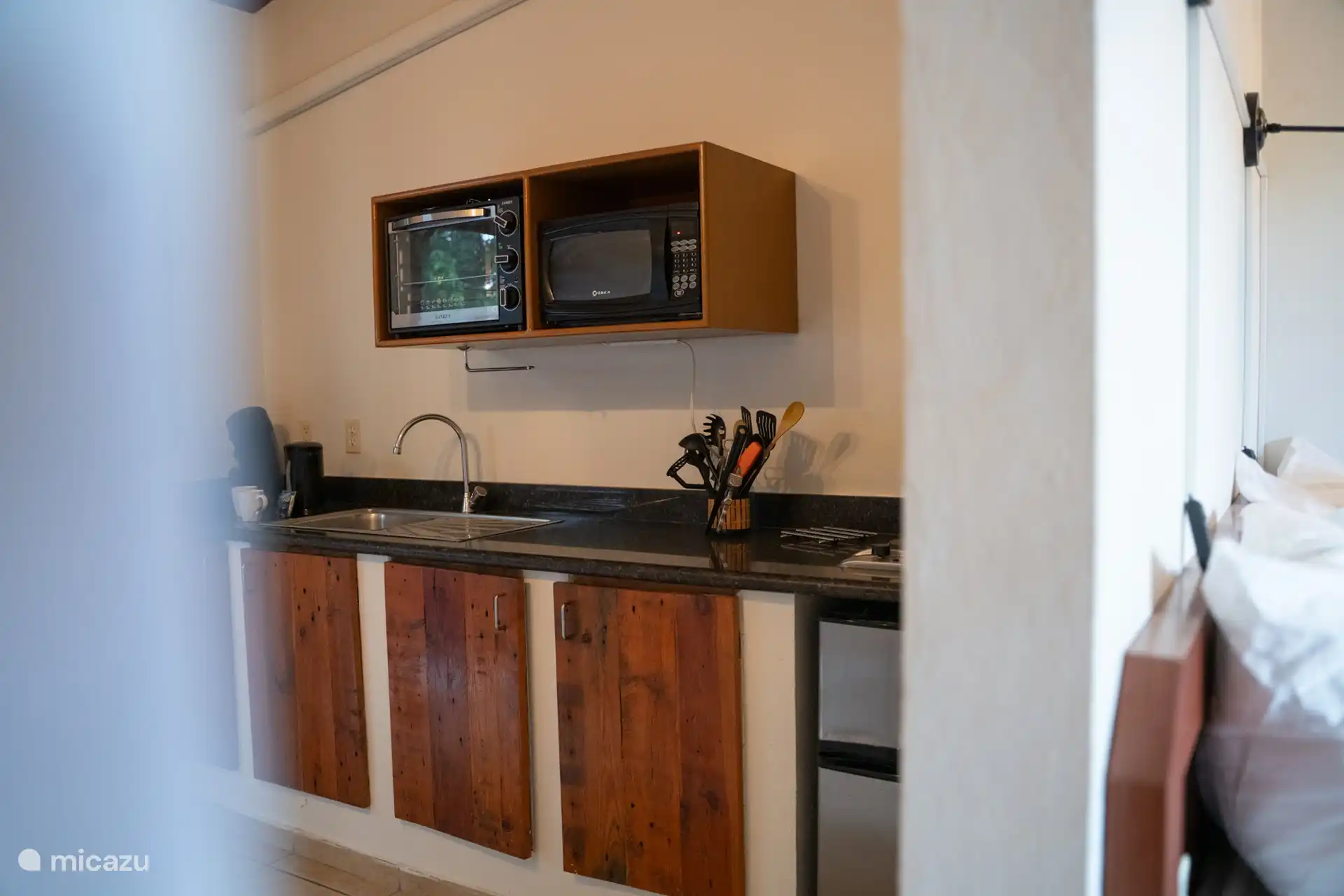 Voll ausgestattete offene Küche mit Mikrowelle, Backofen, Kühlschrank, Herd und allem, was Sie brauchen, um während Ihres Aufenthalts selbst zu kochen.