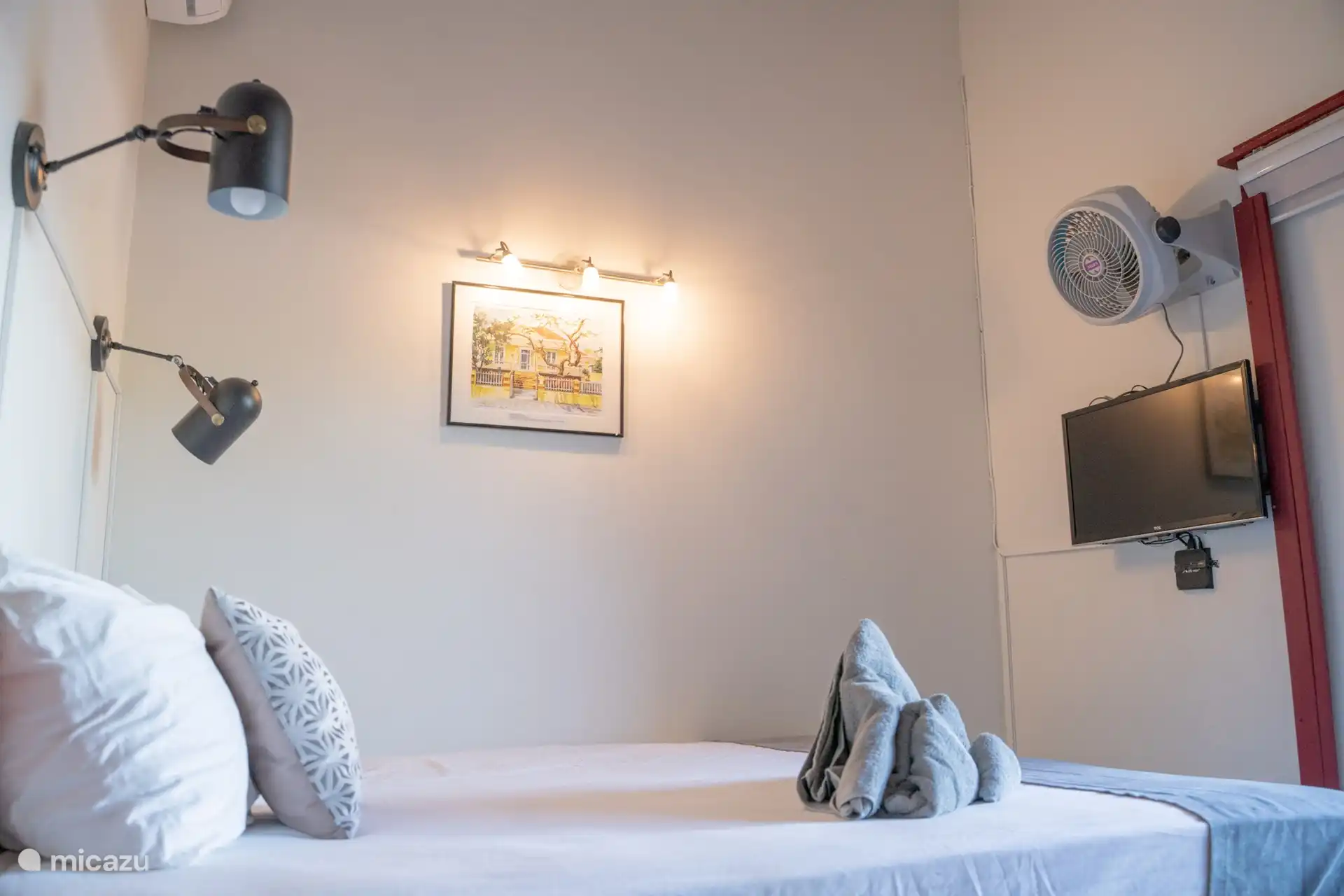 Attraktives Schlafzimmer mit bequemem Bett, modernem TV und sorgfältig ausgewählter Dekoration für eine gemütliche und entspannende Atmosphäre.