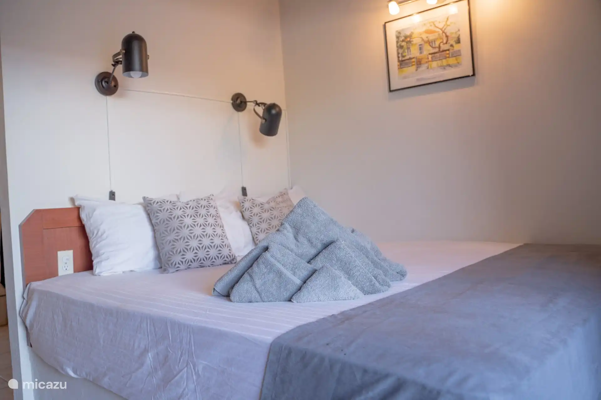 Gemütliches Schlafzimmer mit stilvollem Bett, warmer Beleuchtung und einer entspannenden Atmosphäre. Perfekt zum Entspannen nach einem sonnigen Tag