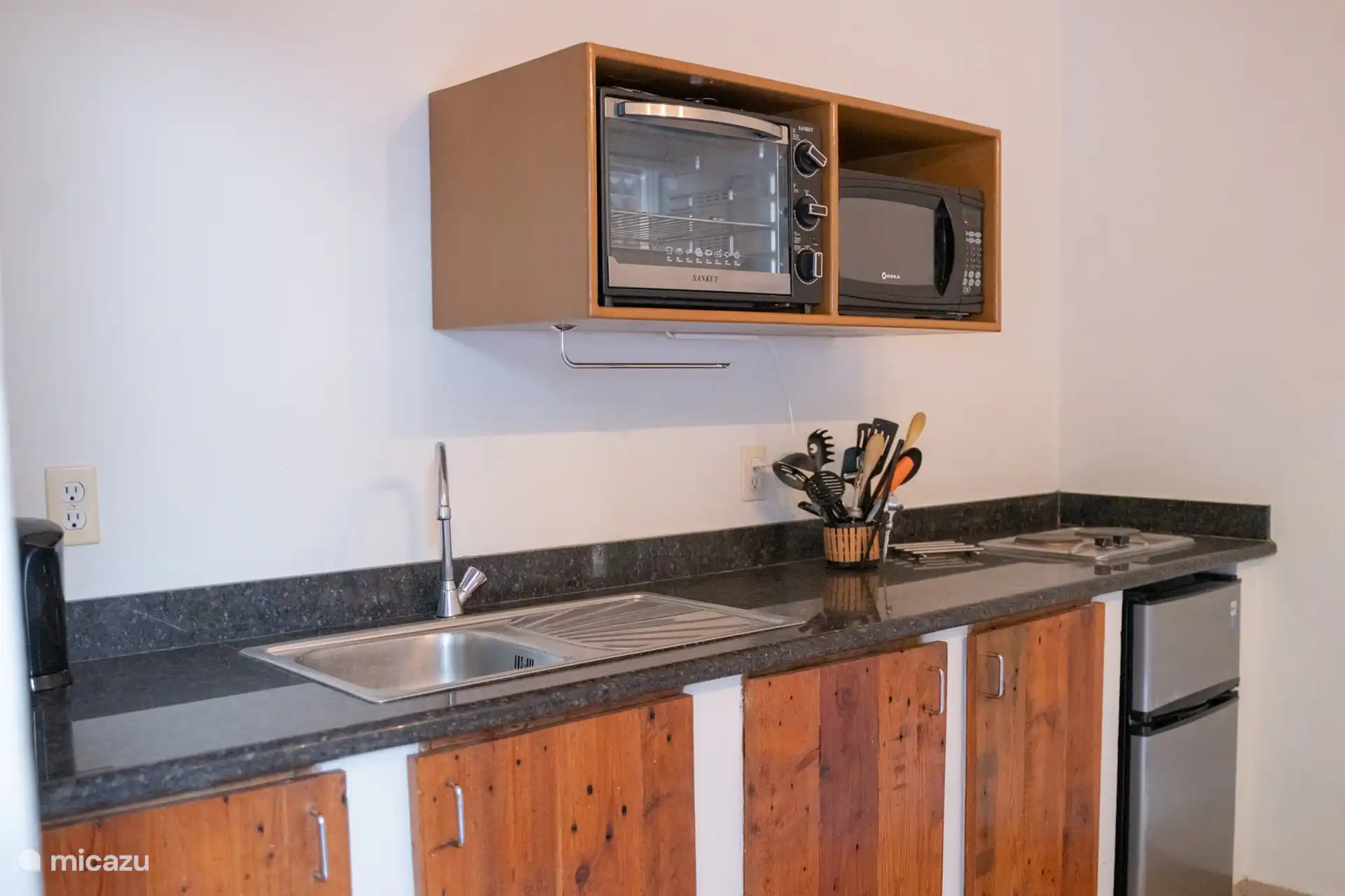 Voll ausgestattete offene Küche mit Mikrowelle, Backofen, Kühlschrank, Herd und allen Notwendigkeiten, um während deines Aufenthalts selbst zu kochen