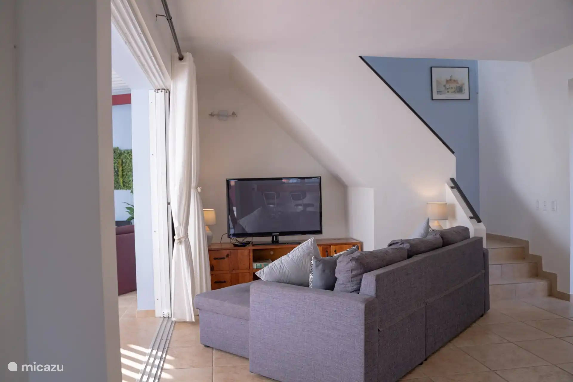 Geräumiges, offenes Wohnzimmer mit bequemem Sofa und modernem TV.