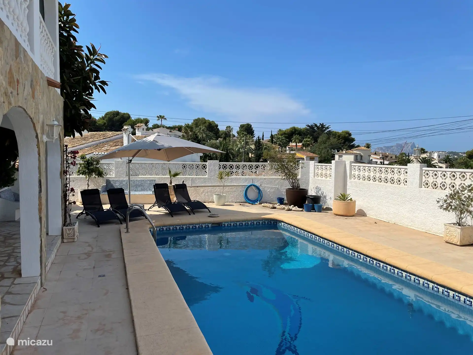 Piscine avec transats et parasol.