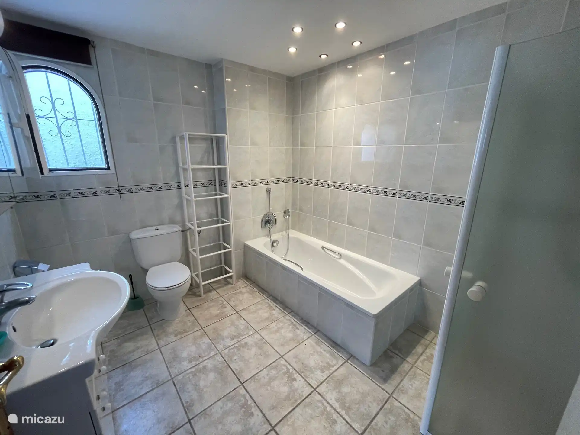 Salle de bain avec baignoire et douche, accessible aux personnes en fauteuil roulant. Appartement rez de piscine,