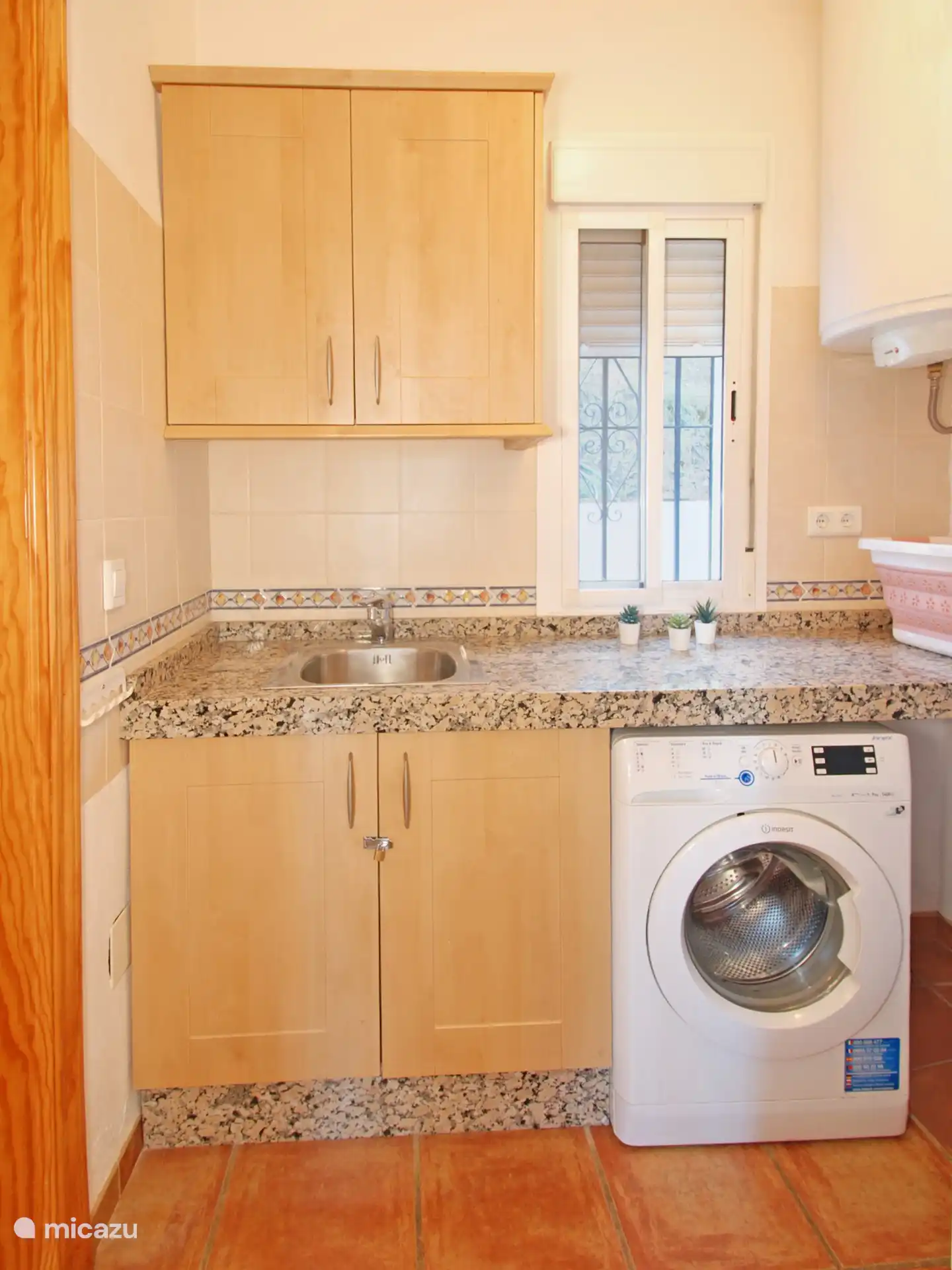 Cocina americana en el estudio con lavadora y cafetera para los más madrugadores.