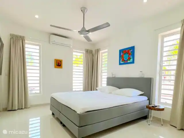Villa Leoni en Curazao, Banda Arriba (este), Brakkeput Abou - apartamento El dormitorio de la diosa cuenta con baño privado, aire acondicionado, ventilador de techo, televisor 4K de 65 pulgadas, walk-in closet y una cómoda área de trabajo.