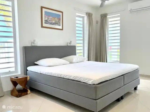 Villa Leoni en Curazao, Banda Arriba (este), Brakkeput Abou - apartamento La habitación del puerto cuenta con baño privado, aire acondicionado, ventilador de techo, televisión 4K de 65 pulgadas, walk-in closet y una cómoda área de trabajo.