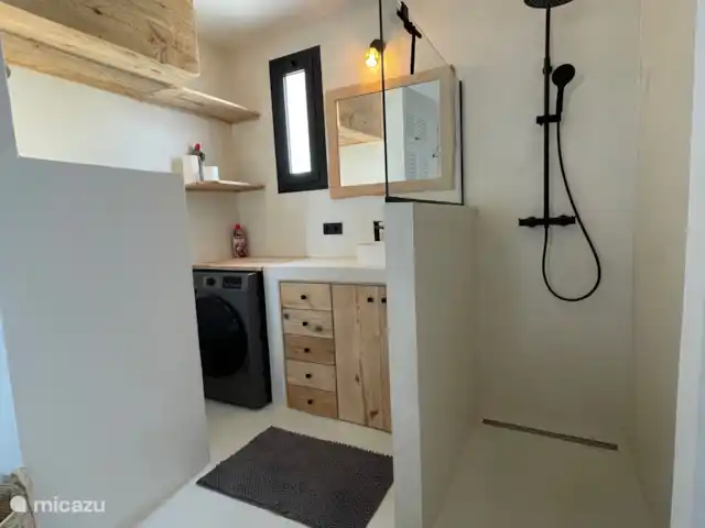 apartamento en España, Ibiza, Cala Llenya – Casa Josine Cala Llenya Baño integrado con ducha, lavabo, inodoro y combinación de lavadora/secadora.