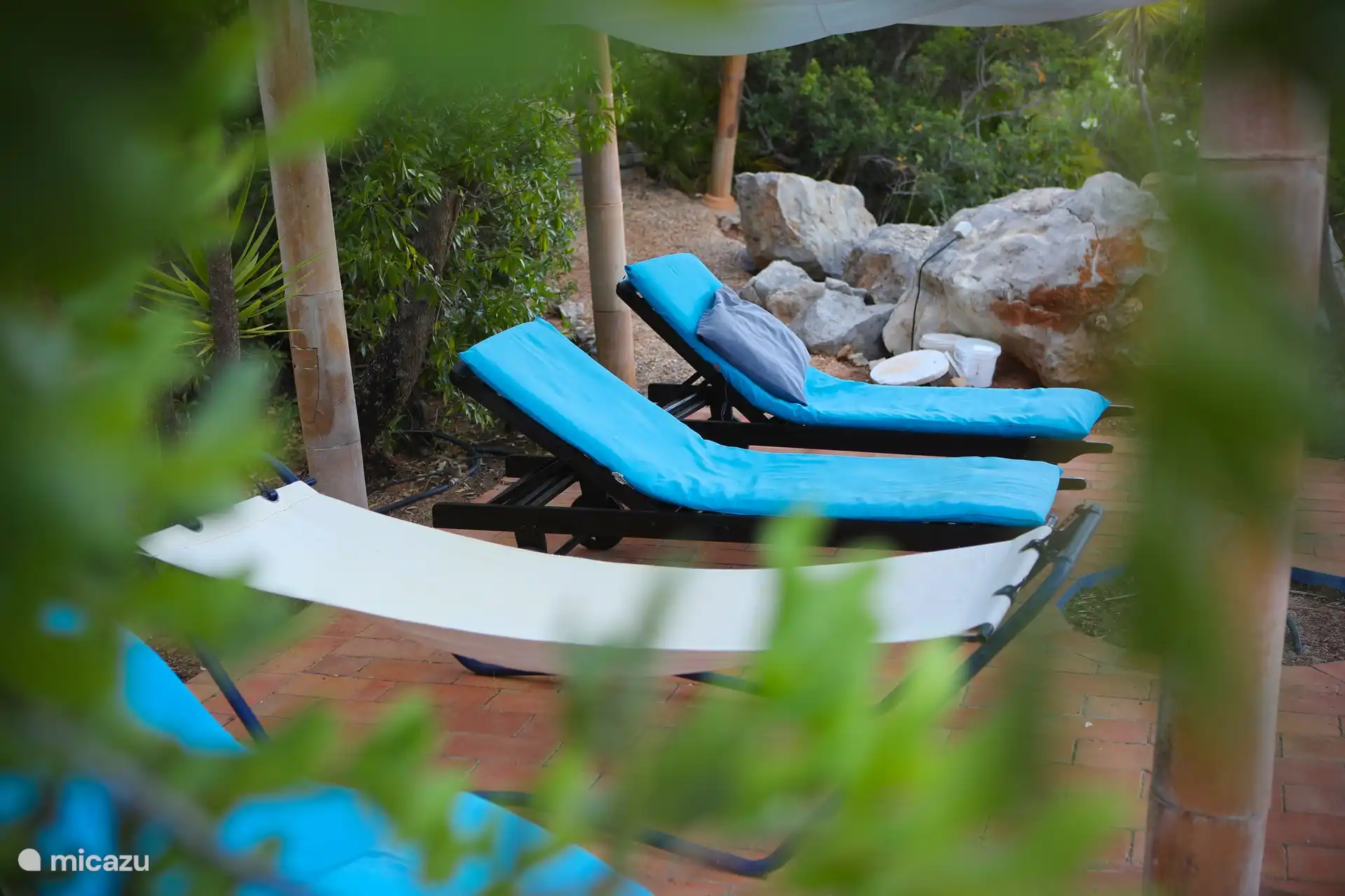 Doe Poollandschaft  mit Liegen und Schattentuechern.