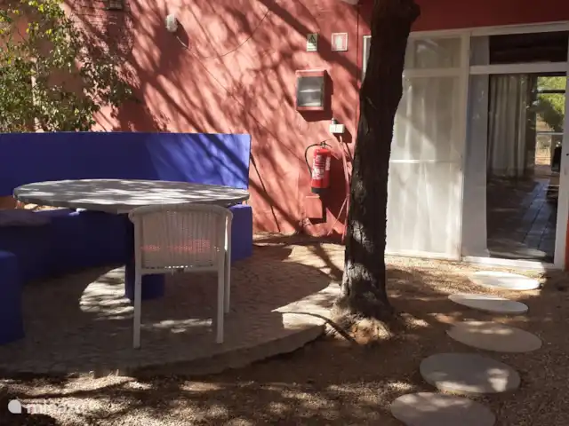 Maison du Théâtre | Portugal, Algarve, Tavira - maison de vacances Ici, vous pouvez voir la salle à manger adjacente à la maison sous un pin et l’entrée de la maison,
