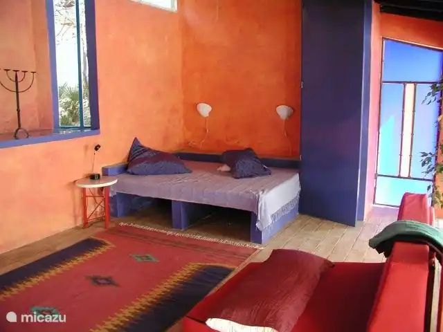 Es gibt ein weiteres Doppelbett zum lesen und faulenzen und angrenzendem Schrank sowie die  blaue Eingangstuer zum Schlafzimmer.