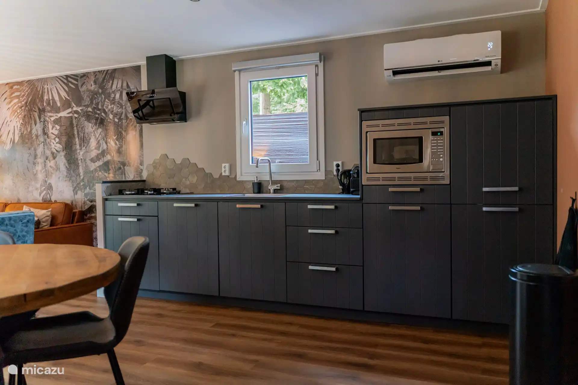 Die Küche verfügt über einen Geschirrspüler, eine Kombi-Mikrowelle, einen Kühlschrank mit Gefrierfach, einen Gasherd und eine Dunstabzugshaube. 